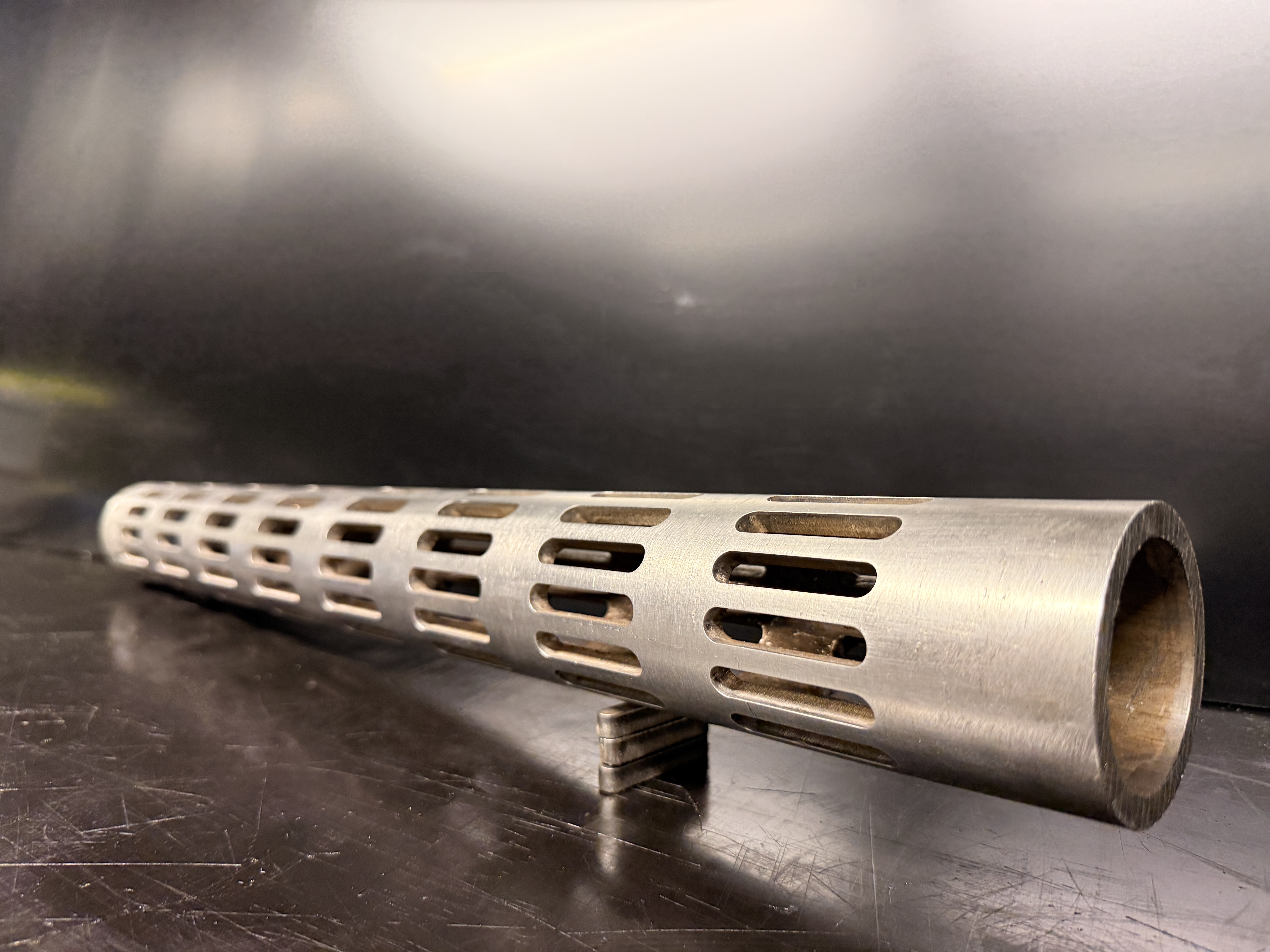 Two stacks of rectangular tube components with laser-cut holes
