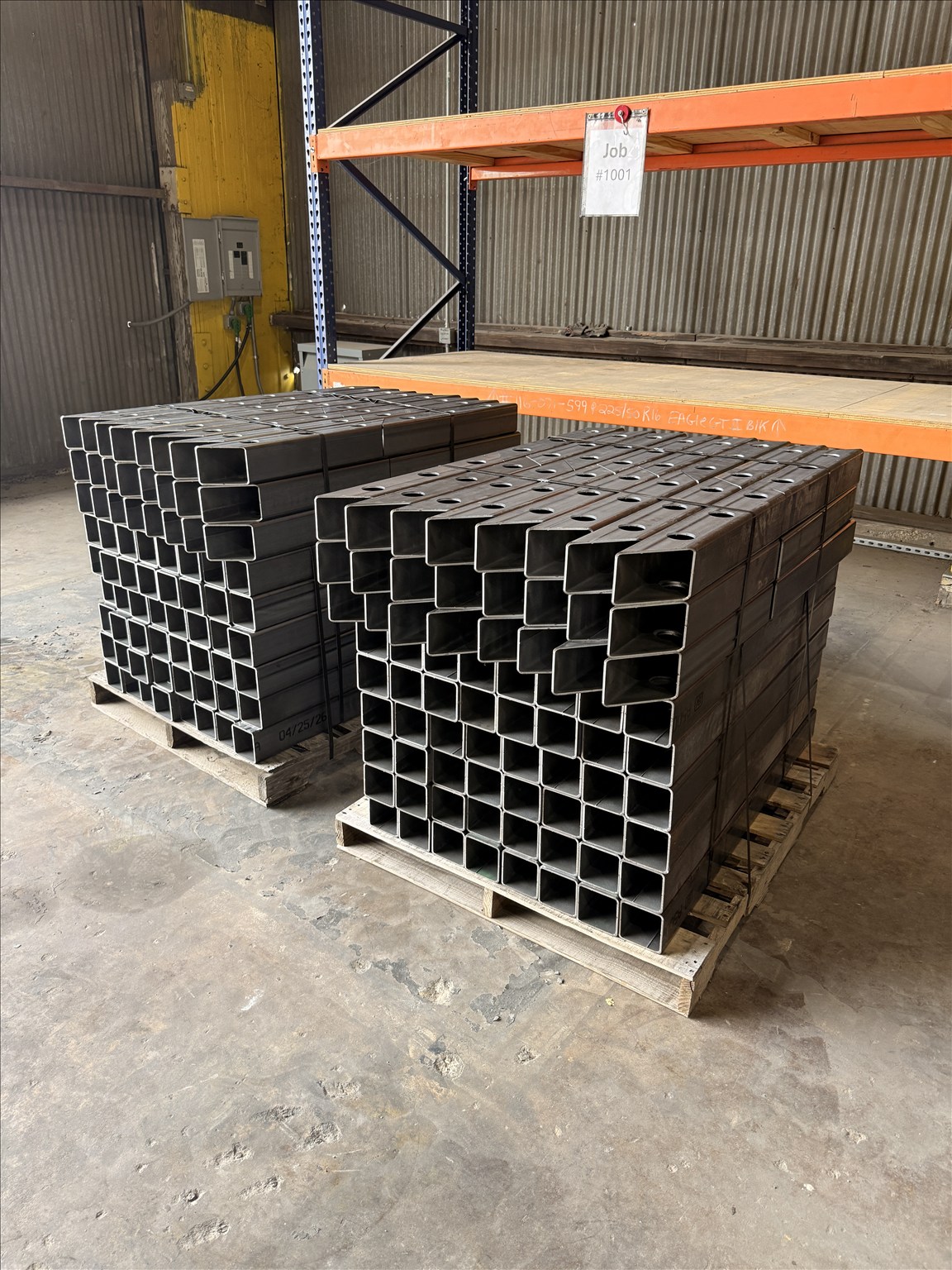 Two stacks of rectangular tube components with laser-cut holes